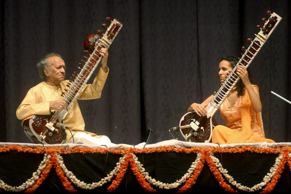 Fotó: RAVI RAVEENDRAN / AFP Az indiai klasszikus zenész, Ravi Shankar (L) és lánya, Anoushka Shankar szitárokat játszanak, miközben fellépnek egy ünnepségen, amellyel tisztelegnek Beatle George Harrison előtt születésnapjának évfordulóján, Újdelhiben, 2004. február 25-én. Harrisonra és a The Beatles többi tagjára Shankar sittárjátéka hatott az 1960-as években.