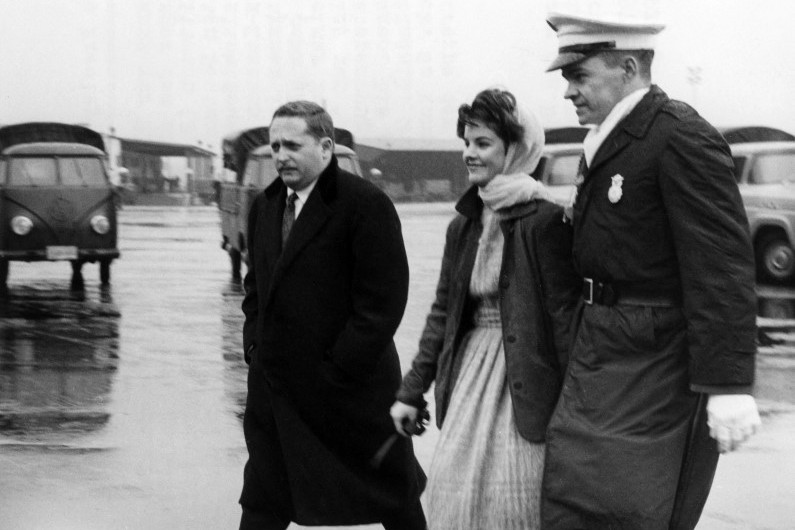 Fotó: Richard Koll / DPA / dpa Picture-Alliance A 16 éves Priscilla Beaulieu-t egy rendőr kíséri a frankfurti katonai légibázison 1960. március 2-án. Az amerikai rock'n roll énekes, Elvis Presley barátnője és későbbi felesége azért lépte át a rendőrök kordonját, hogy elbúcsúzzon Elvistől az Egyesült Államokba való visszarepülése előtt