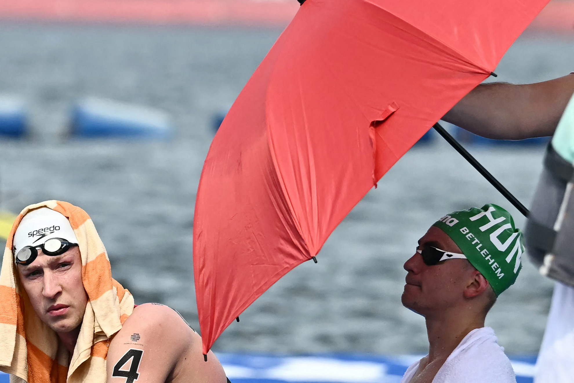 A német úszó Florian Wellbrock (b) és Betlehem David pihen a férfi 3 km-es kiütéses sprint nyíltvízi úszás egyik futama után a 2025-ös vizes világbajnokságon a szingapúri Sentosa-szigeten 2025. július 19-én